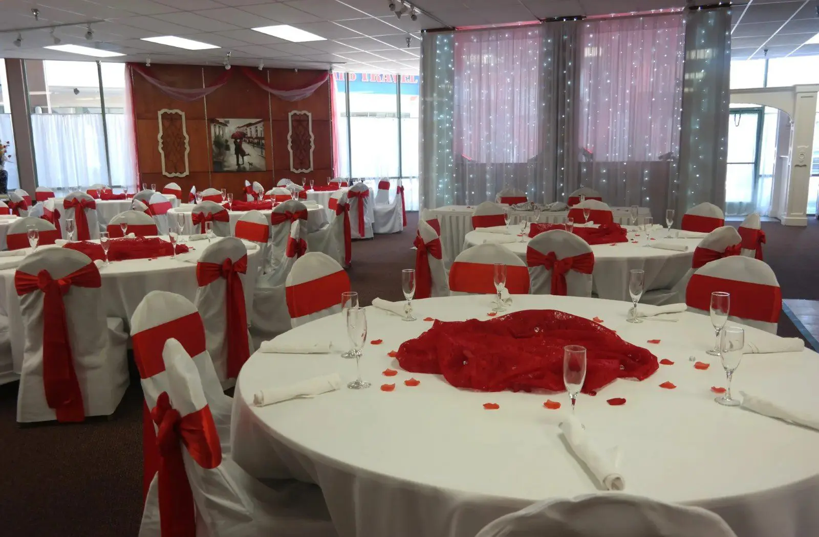 A room with many tables and chairs covered in red roses.