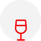 A red wine glass sitting in front of a white circle.